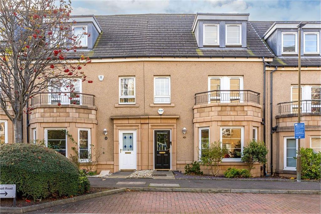 The exterior of a modern terraced house with a balcony.